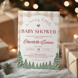 K&ouml;nnte beinhalten: Eine Babyparty-Einladung mit festlichem Design. Die Karte zeigt den Text "a merry little BABY SHOWER" in roter Schrift, zusammen mit dem Namen "Charlotte Evans" und Veranstaltungsdetails. Die Einladung ist von verpackten Geschenken und Gr&uuml;n umgeben.