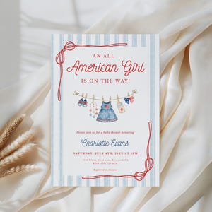 May include: A rectangular baby shower invitation card with a light blue and white striped border and red rope accents. The text reads AN ALL AMERICAN GIRL IS ON THE WAY! with a clothesline graphic featuring baby items and event details for Charlotte Evans.