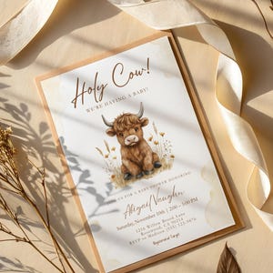 May include: A rectangular baby shower invitation card featuring a brown highland cow illustration, wheat stalks, and the text Holy Cow! We're having a baby! Join us for a baby shower honoring Abigail Vaughn, Saturday, November 10th, 2:00-5:00 PM.