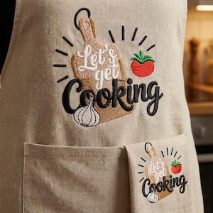 May include: Beige apron with embroidered design. Features a cutting board, tomato, and garlic with the text "Let's get Cooking". Includes a front pocket and a matching small towel with the same design.