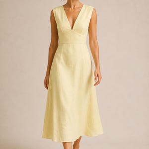Puede incluir: Un vestido midi sin mangas de color amarillo p&aacute;lido con un escote en V profundo, un corpi&ntilde;o ajustado con cintura definida y una falda acampanada en forma de A que cae por debajo de las rodillas. La prenda tiene un dise&ntilde;o liso y limpio.