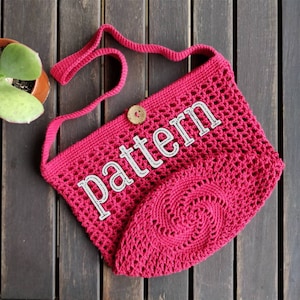 May include: A crocheted pink bag with a long strap and a round crocheted bottom. The bag has a wooden button and the word "pattern" written on it.