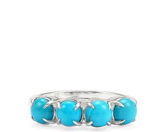 May include: A silver ring featuring four round, bright turquoise stones. The stones are set in individual prongs along the band. The ring is a simple, elegant design.