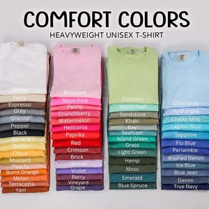 a collection of various colored t-shirts, each with a different color and design, arranged in two rows.