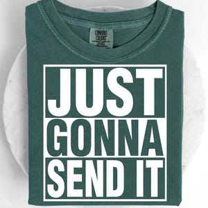 A green t-shirt with the text "JUST GONNA SEND IT" printed on it.