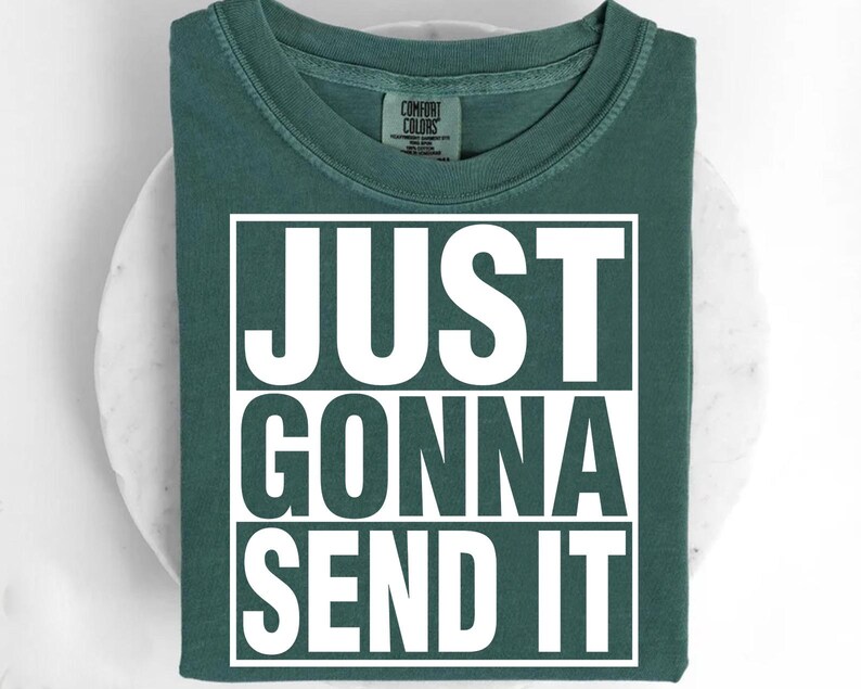 A green t-shirt with the text "JUST GONNA SEND IT" printed on it.