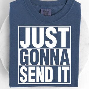 A blue t-shirt with the text "JUST GONNA SEND IT" printed on it.