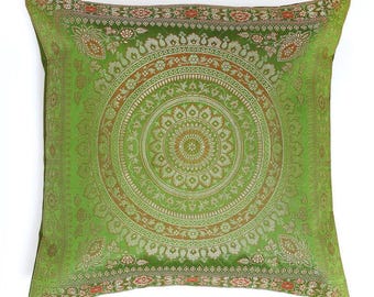 May include: A square cushion featuring a vibrant green backdrop and a detailed circular design in gold and brown tones. The cushion's border is adorned with floral and geometric patterns, offering an elegant touch to interior decor.