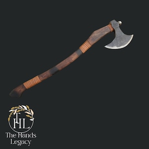 May include: A handcrafted axe with a dark wooden handle and a metal blade. The handle is wrapped with leather and features a dark band. The axe is designed for chopping and cutting.