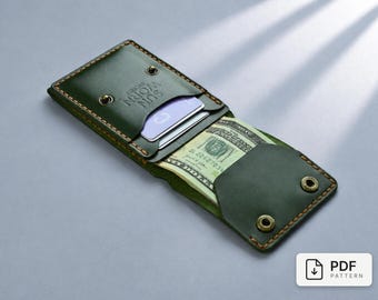 May include: A dark green leather wallet with visible orange stitching and brass-colored snap buttons. The wallet features the embossed text SUN WORN SYDNEY and contains a stack of US dollar bills and two cards tucked into the interior slots.