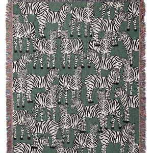 May include: A woven throw blanket featuring a repeating pattern of zebras in black and white against a green background. The blanket has a fringed edge with a mix of colors. This decorative blanket is suitable for home decor.