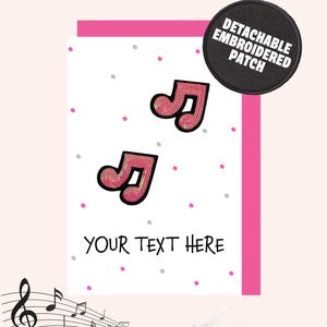 May include: A white card featuring pink musical notes and the words "YOUR TEXT HERE". The card has a pink border and is decorated with small pink and silver dots. A black, round patch with the text "DETACHABLE EMBROIDERED PATCH" is in the upper right corner.