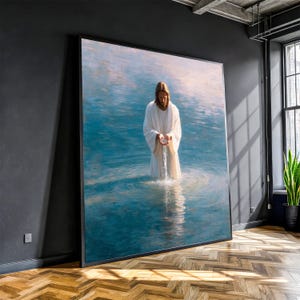 Op de afbeelding: Groot ingelijst kunstwerk met een figuur in witte gewaden die in blauw water staat. De figuur houdt water vast dat uit zijn handen stroomt. Het kunstwerk wordt tentoongesteld aan een donkere muur in een kamer met een houten vloer.