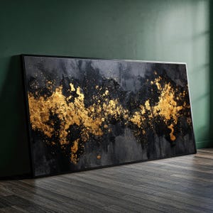 May include: A rectangular wall art piece featuring a black and dark grey textured background with a prominent horizontal band of metallic gold paint splatters and abstract shapes across the centre, enclosed within a thin black frame.