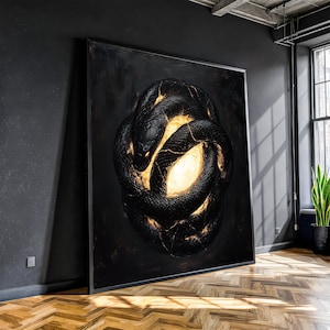 Puede incluir: Gran obra de arte enmarcada que representa una serpiente negra enrollada con grietas doradas brillantes y un centro brillante. Las escamas de la serpiente están detalladas y la obra de arte tiene una estética oscura y dramática. La pieza se exhibe en un entorno interior moderno.