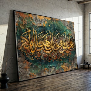 May include: Large framed artwork featuring gold Arabic calligraphy on a textured background. The artwork has a distressed look with teal, gold, and brown tones. The frame is black, and the piece is leaning against a gray wall.