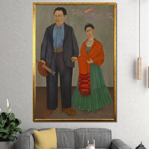 May include: A framed painting featuring two figures holding hands. The man wears a dark suit and holds a guitar. The woman is in a green dress and a red shawl. A bird and banner are in the background. The frame is gold.