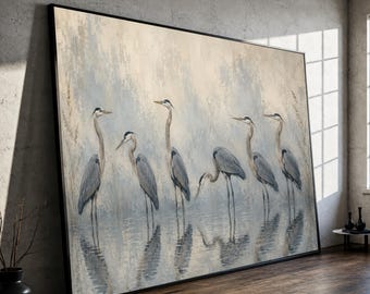 May include: A large rectangular wall art piece featuring a painting of six grey herons standing in shallow water. The birds are depicted in various poses against a soft, muted background of pale blue and cream tones with subtle reflections.