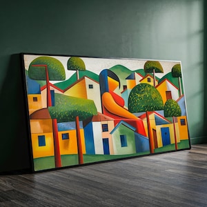 May include: A framed abstract painting depicting a stylized village scene. The artwork features a seated figure in red and orange, surrounded by colorful houses, trees, and green hills. The painting is set against a dark green wall and a dark wood floor.