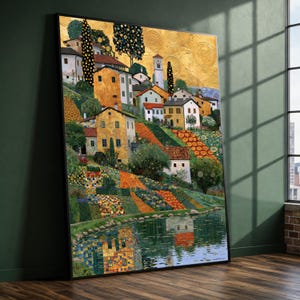 Puede incluir: Una impresión de arte mural enmarcada que representa un paisaje con casas, árboles y un cielo dorado reflejado en el agua. La escena muestra un pueblo en la ladera con edificios blancos y amarillos, tejados rojos y parcelas de jardín estampadas.
