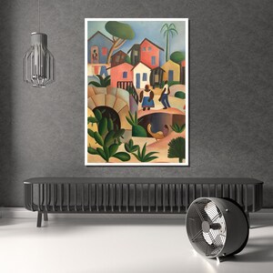 Puede incluir: Una pintura enmarcada representa una colorida escena de pueblo. La obra presenta casas en tonos rojos, azules y amarillos, con figuras de personas y exuberante vegetaci&oacute;n verde. Tambi&eacute;n se ve un puente y un arco.