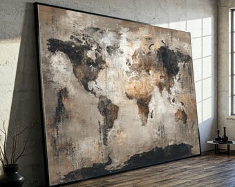May include: Large framed world map art print. The artwork features a textured, abstract design with continents in shades of brown, black, and beige against a neutral background. The map is encased in a black frame, leaning against a textured wall.