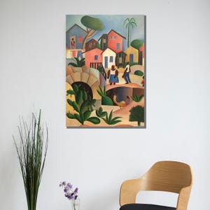 Puede incluir: Pintura enmarcada que representa una colorida escena de pueblo. La obra presenta casas en tonos azules, rojos y amarillos, con figuras de personas y exuberante vegetaci&oacute;n verde. Tambi&eacute;n se ve un puente y un cactus.