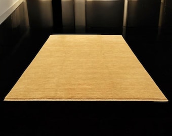 May include: A rectangular, golden-yellow rug with a soft, textured surface. The rug is placed on a glossy black floor, creating a contrast. The rug's edges are neatly finished, suggesting a high-quality product. The overall theme is home decor.