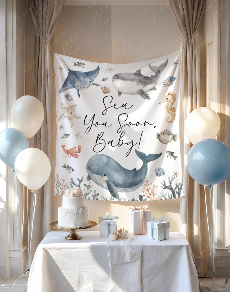 May include: A baby shower setup with a white cake, gifts, and balloons. A backdrop displays sea creatures and the text "Sea You Soon, Baby!". The colour scheme includes white, blue, and gold accents, creating a celebratory atmosphere.