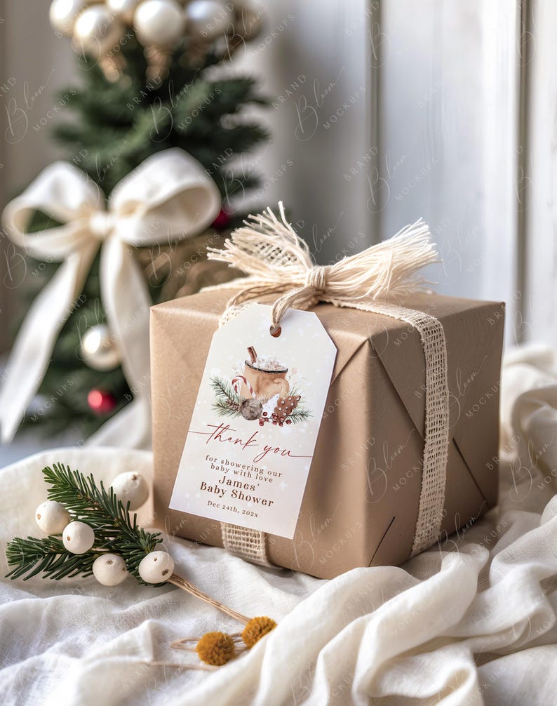May include: A wrapped gift box with a tag that reads "Thank you" for a baby shower. The box is wrapped in brown paper and tied with a burlap ribbon. The tag features a watercolor illustration of a mug of hot cocoa.