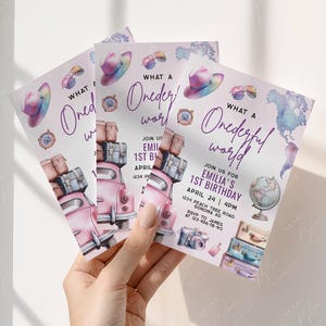 May include: Three invitation cards with a watercolor design. The cards feature a pink car loaded with luggage, a hat, sunglasses, a compass, and the text "What a Wonderful World." The invitation is for Emilia's 1st birthday.