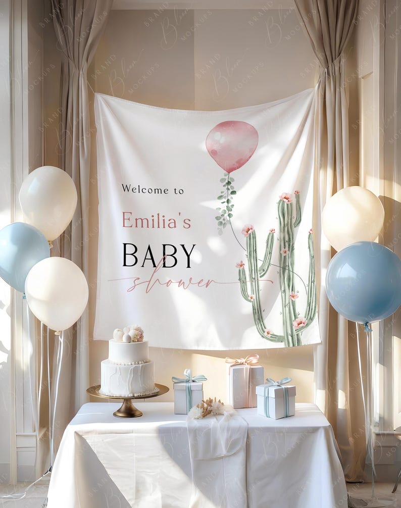 May include: A baby shower setup with a white banner displaying a pink balloon and cactus design, with the text "Welcome to Emilia's BABY shower." A two-tiered cake, gifts, and white and blue balloons are arranged on a table.