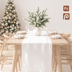 May include: A dining table set for a holiday meal. The table is set with white plates, wine glasses, and a white table runner. A white vase holds a green and white floral arrangement. A decorated Christmas tree is in the background.