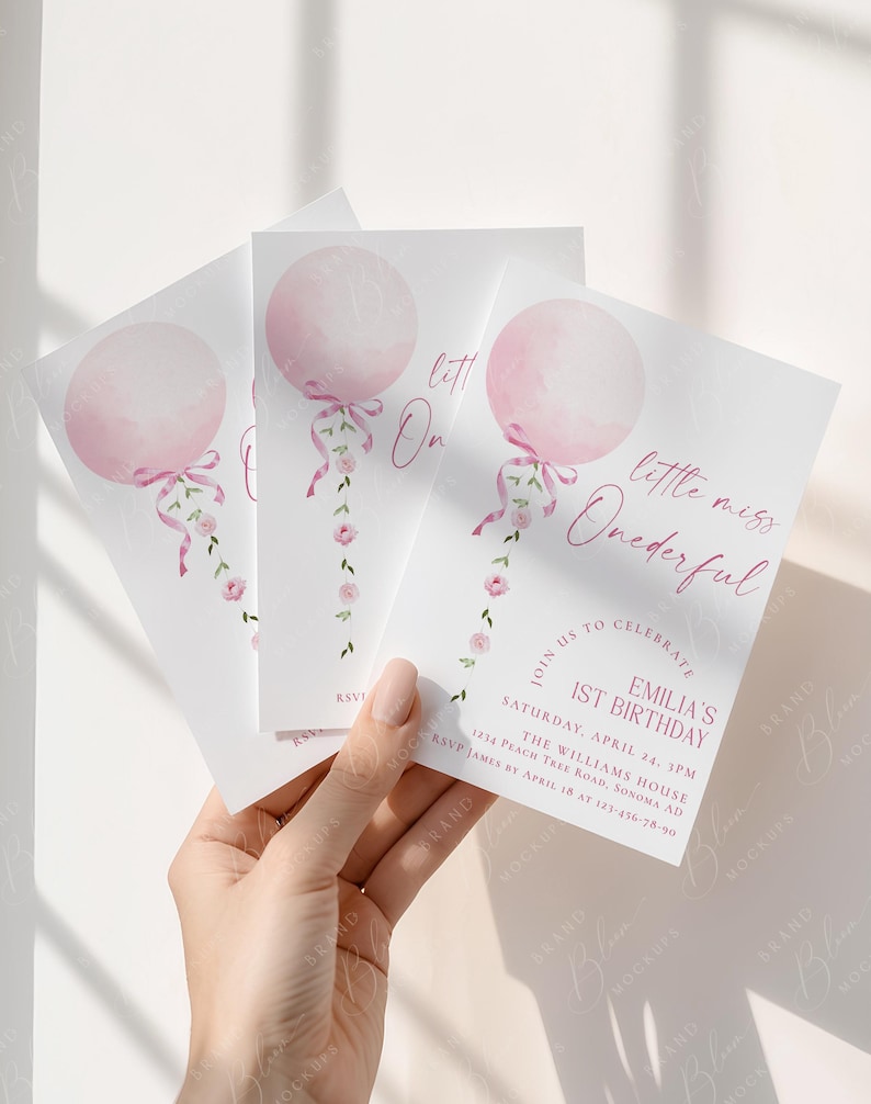 May include: Three white invitation cards with a pink balloon design and the text "little miss Onederful". The cards also include event details for a first birthday celebration, with a floral accent.
