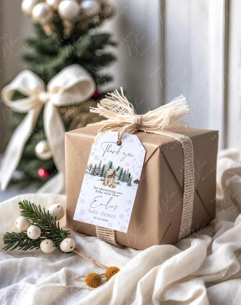 May include: A wrapped gift in brown paper with a tag that says "Thank you" and "baby shower". The tag features a winter scene with a bear. The gift is tied with a burlap ribbon and a white bow.
