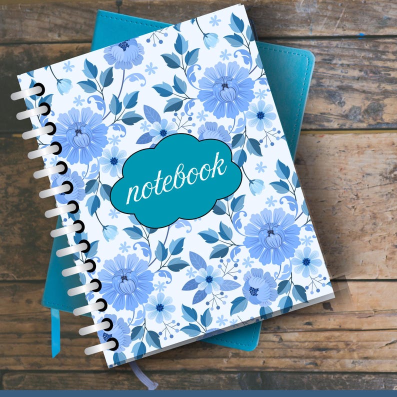 May include: A spiral-bound notebook with a floral design in shades of blue and white. The cover features a cloud-shaped label with the word "notebook" in cursive. A teal notebook is visible underneath.