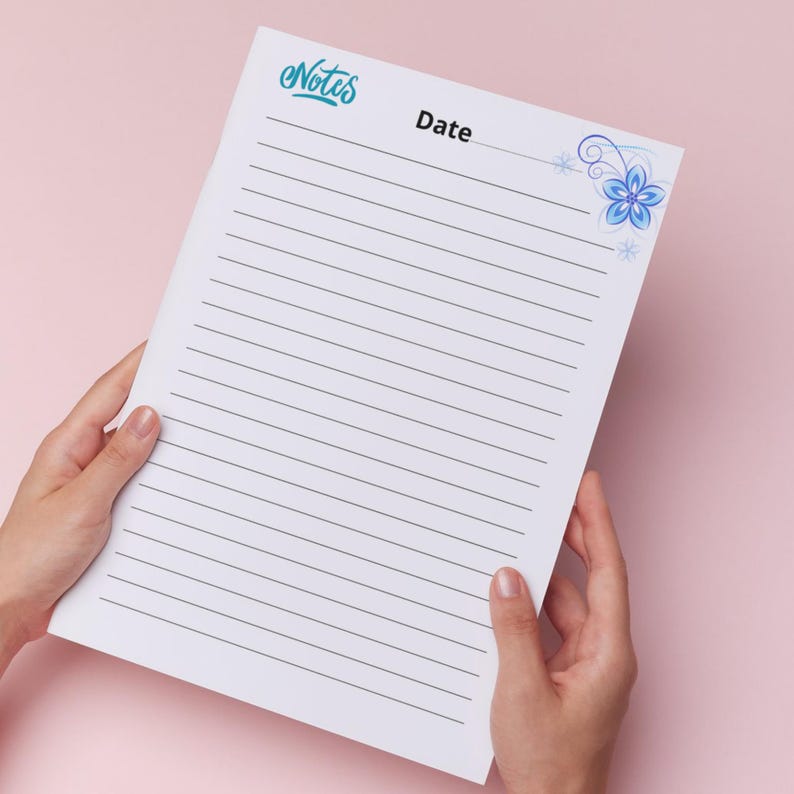 May include: A white lined notepad with the word "Notes" in teal script at the top left and "Date" in black text. A blue floral design is in the top right corner. The notepad is held by two hands against a pink background.