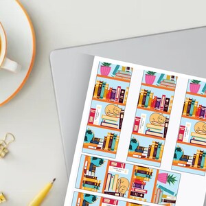 May include: A printed sheet featuring a repeating pattern of bookshelves with books, a sleeping cat, and potted plants. The design includes a globe and a pink pot with a plant. A cup of coffee and office supplies are in the background.