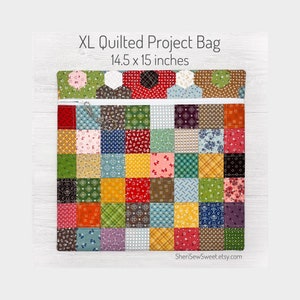 May include: A quilted project bag with a patchwork design in various colors, including red, green, blue, yellow, and brown. The bag is 14.5 x 15 inches and has a zipper closure. The bag is made of fabric and has a quilted texture. The bag is on a white wooden background.