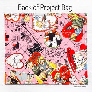 May include: Pink fabric with a repeating pattern of vintage Valentine's Day cards and images. The fabric features hearts, red and white stripes, and the text "Valentine", "Post Card", "February Fourteen", and "You're just cut out for me".