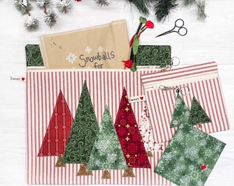 May include: A collection of Christmas-themed fabric pouches and accessories. The main pouch features red and white striped fabric with appliqued Christmas trees. Other items include a small zippered pouch, a tree-shaped charm, and a snowflake-patterned square. The text "Snowballs for" is visible.