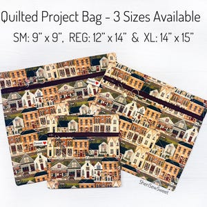 May include: Three quilted project bags in varying sizes, featuring a repeating pattern of quaint buildings. The bags are labeled SM (9" x 9"), REG (12" x 14"), and XL (14" x 15"). Each bag has a zipper closure and a "Sweet" tag.
