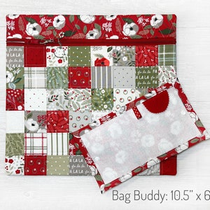 K&ouml;nnte beinhalten: Ein Patchwork-Bag Buddy, 26,7 cm x 15,2 cm, aus roten, gr&uuml;nen und wei&szlig;en Stoffen. Das Design zeigt Quadrate mit floralen und festlichen Mustern. Ein roter Rei&szlig;verschluss verl&auml;uft &uuml;ber die Oberseite. Die offene Klappe hat einen roten Filzakzent.