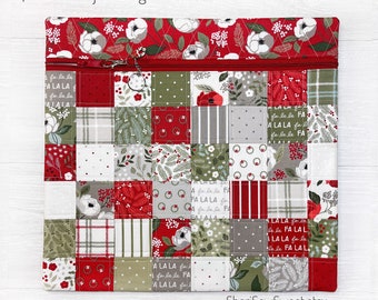 May include: Quilted project bag with a patchwork design in red, green, and gray. The bag features a zipper closure and is available in two sizes: XL 14x15 inches or REG 12x14 inches. The bag is decorated with floral and holiday-themed patterns.