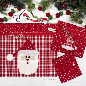 Könnte beinhalten: Drei rot-weiße Stoffbeutel mit einer Weihnachtsmann-Applikation, einem Karomuster und weißen Punkten. Jeder Beutel hat einen Reißverschluss mit einem kleinen Anhänger. Der Text "Sweet" steht auf einem kleinen Etikett an den Beuteln.