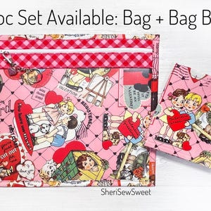 May include: A set of two pink fabric bags with a Valentine's Day theme. The larger bag has a zipper closure and the smaller bag is a simple pouch. Both bags feature a pink and red checkered pattern and a print of children and hearts.