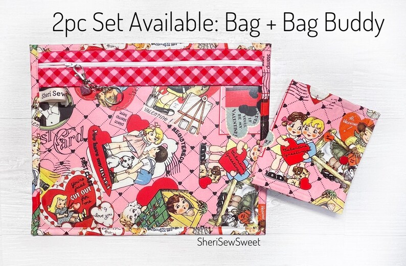 May include: A set of two pink fabric bags with a Valentine's Day theme. The larger bag has a zipper closure and the smaller bag is a simple pouch. Both bags feature a pink and red checkered pattern and a print of children and hearts.