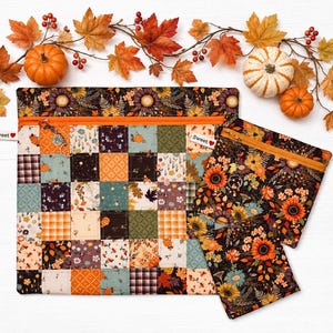May include: Two fabric zipper pouches featuring a patchwork design of autumn-themed patterns including pumpkins, sunflowers, and plaid in orange, brown, and green. Each pouch has an orange zipper, a silver ring pull, and a white tag labeled Sweet.