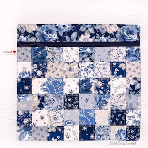 May include: A blue and white patchwork zippered pouch with a floral print. The pouch has a zipper closure and a small charm attached to the zipper pull. The pouch is labeled "Sweet" in red.