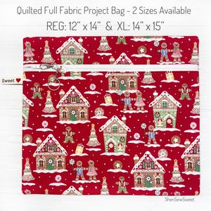 May include: A red quilted fabric project bag with a zipper closure. The bag features a gingerbread house and snowman pattern. The bag is available in two sizes: 12 inches by 14 inches and 14 inches by 15 inches.
